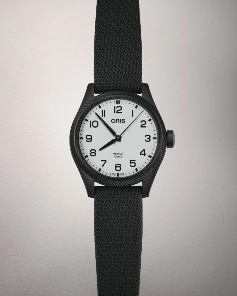 Frontalansicht auf die Oris ProPilot Hölstein Edition 2025 mit weißem Zifferblatt am schwarzen Textilarmband vor hellgrauem Hintergrund