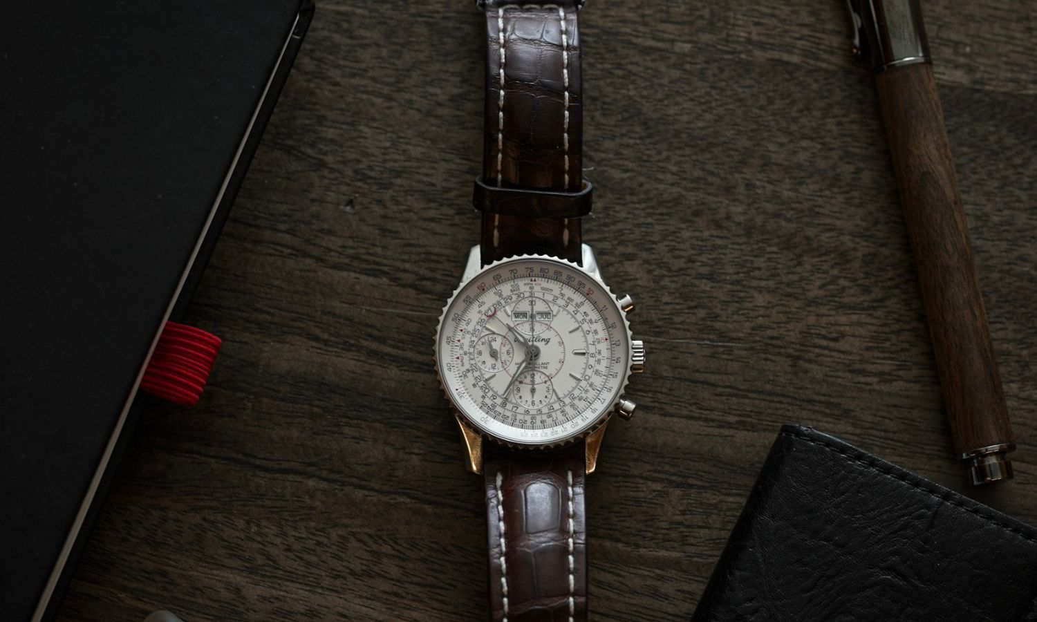 Breitling Navitimer Montbrillant Datora Referenz A2133012 am braunen Alligatorlederarmband fotografiert auf einem braunen Holztisch