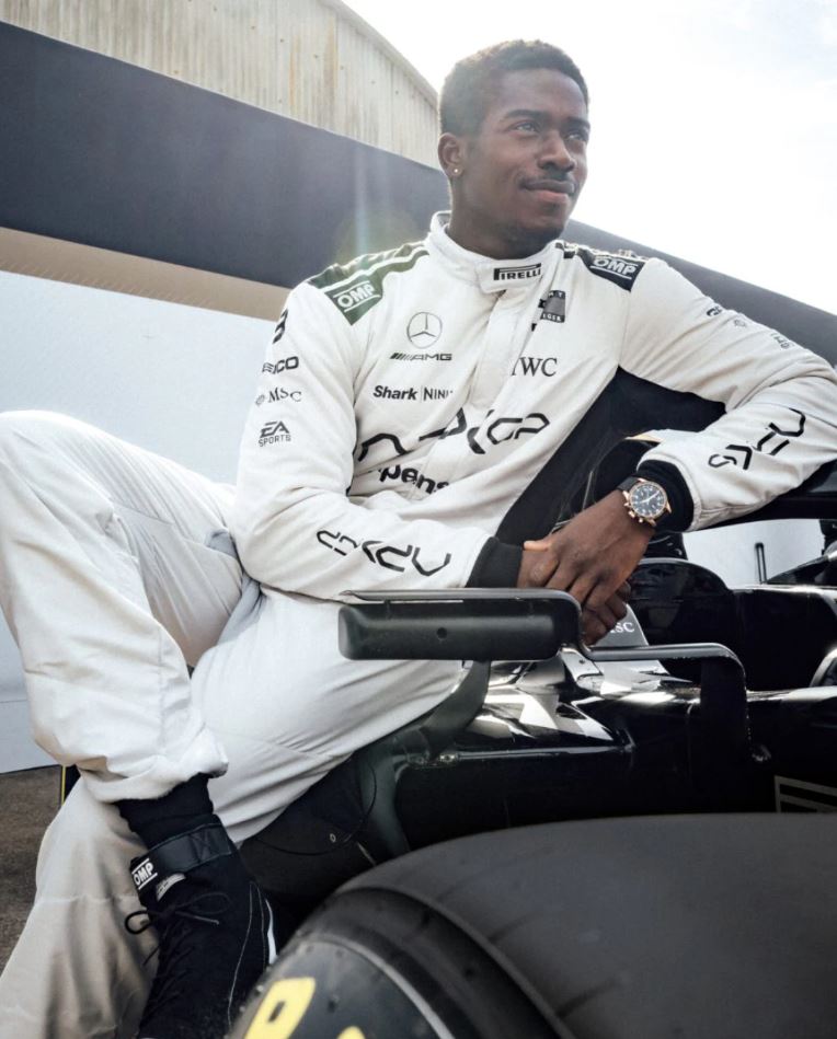 Ein Foto von Joshua Pearce (gespieltvon Damson Idris), der auf seinem F1-Boliden sitzt und eine IWC Pilot’s Watch Performance Chronograph 41 auf dem linken Handgelenk trägt.