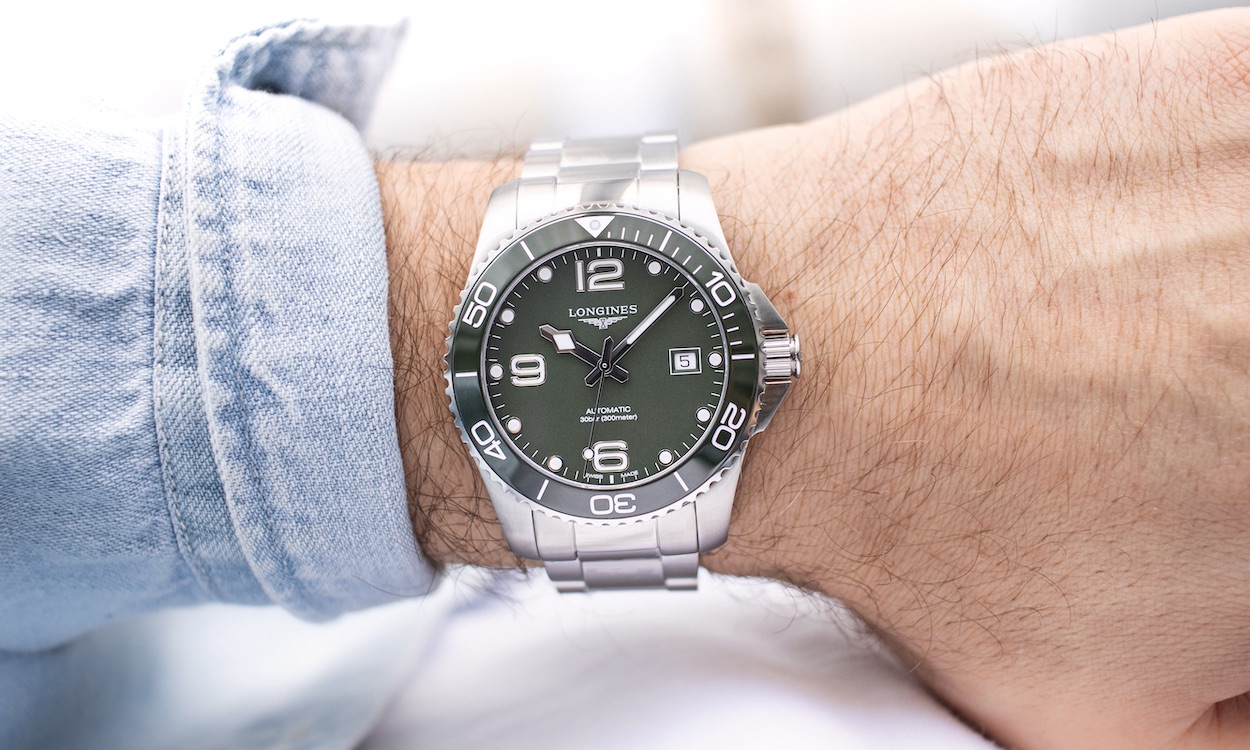Longines HydroConquest am Handgelenk eines Mannes mit hellblauem Oberteil