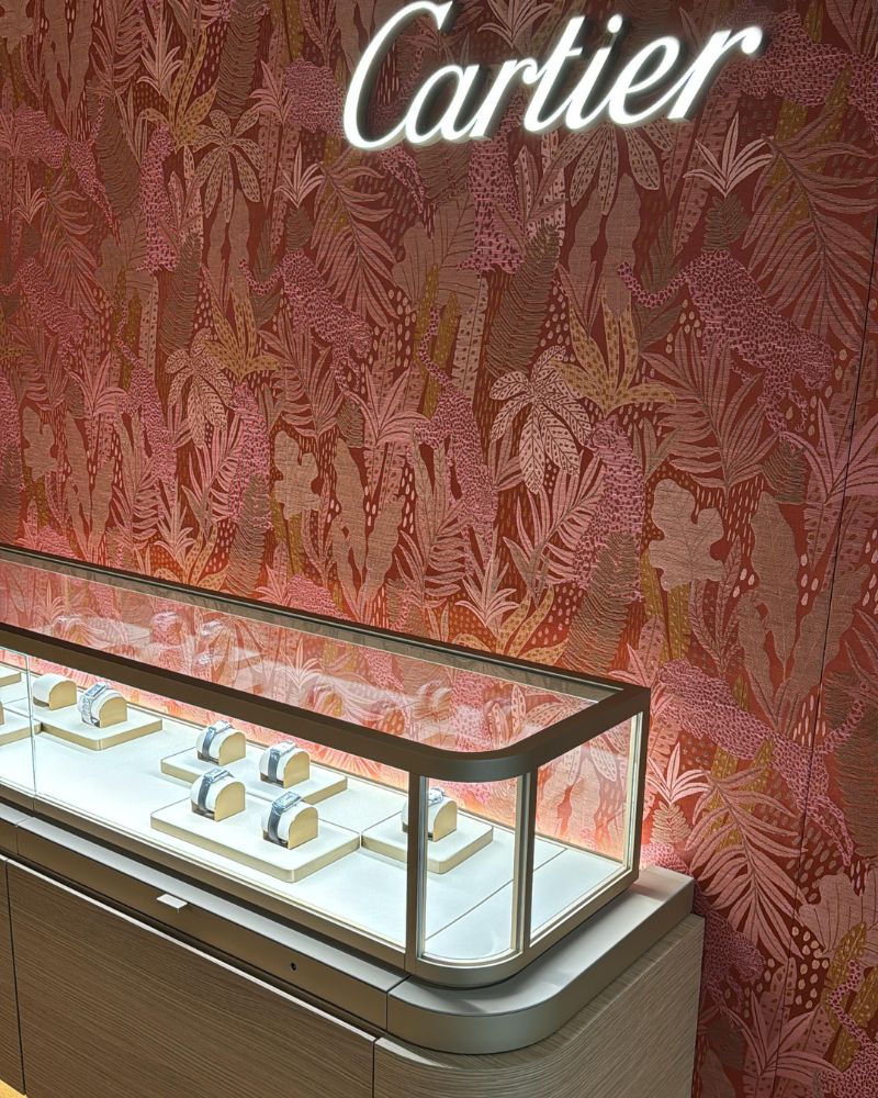 Blick auf die Cartier-Vitrine im ALTHERR-Store mit einem roten Hintergrund.