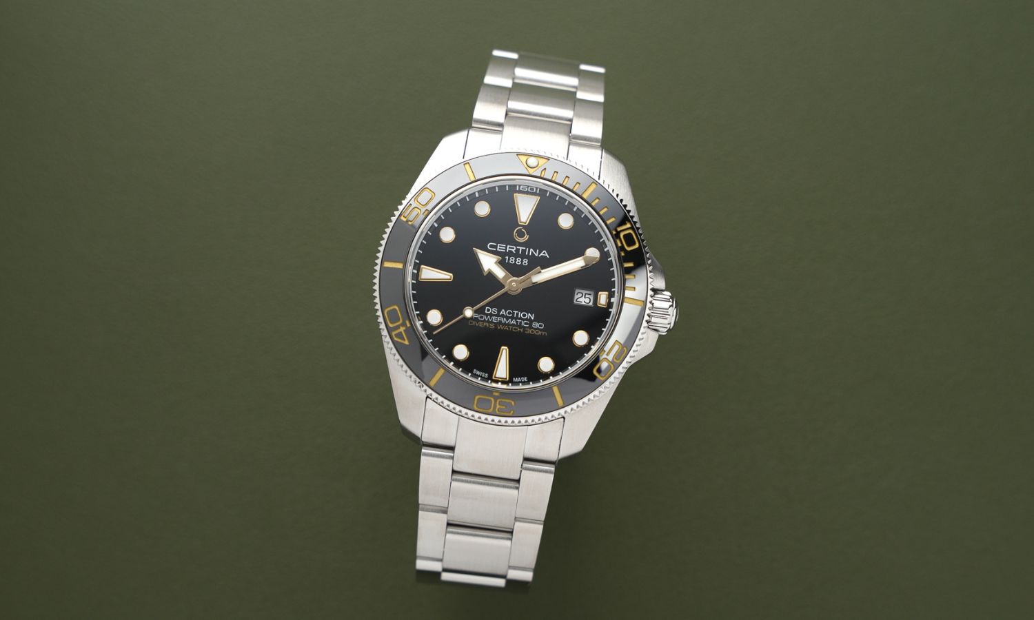 Certina DS Action Diver 40.5mm Powermatic 80 Referenz: C048.407.11.051.01 mit schwarzem Zifferblatt am Edelstahlarmband stehend vor dunkelgrünem Hintergrund