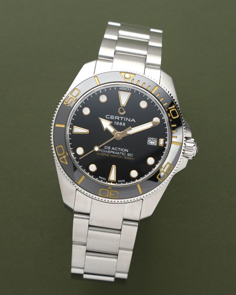 Certina DS Action Diver 40,5mm Powermatic 80 Referenz: C048.407.11.051.01 mit schwarzem Zifferblatt am Edelstahlarmband stehend vor dunkelgrünem Hintergrund