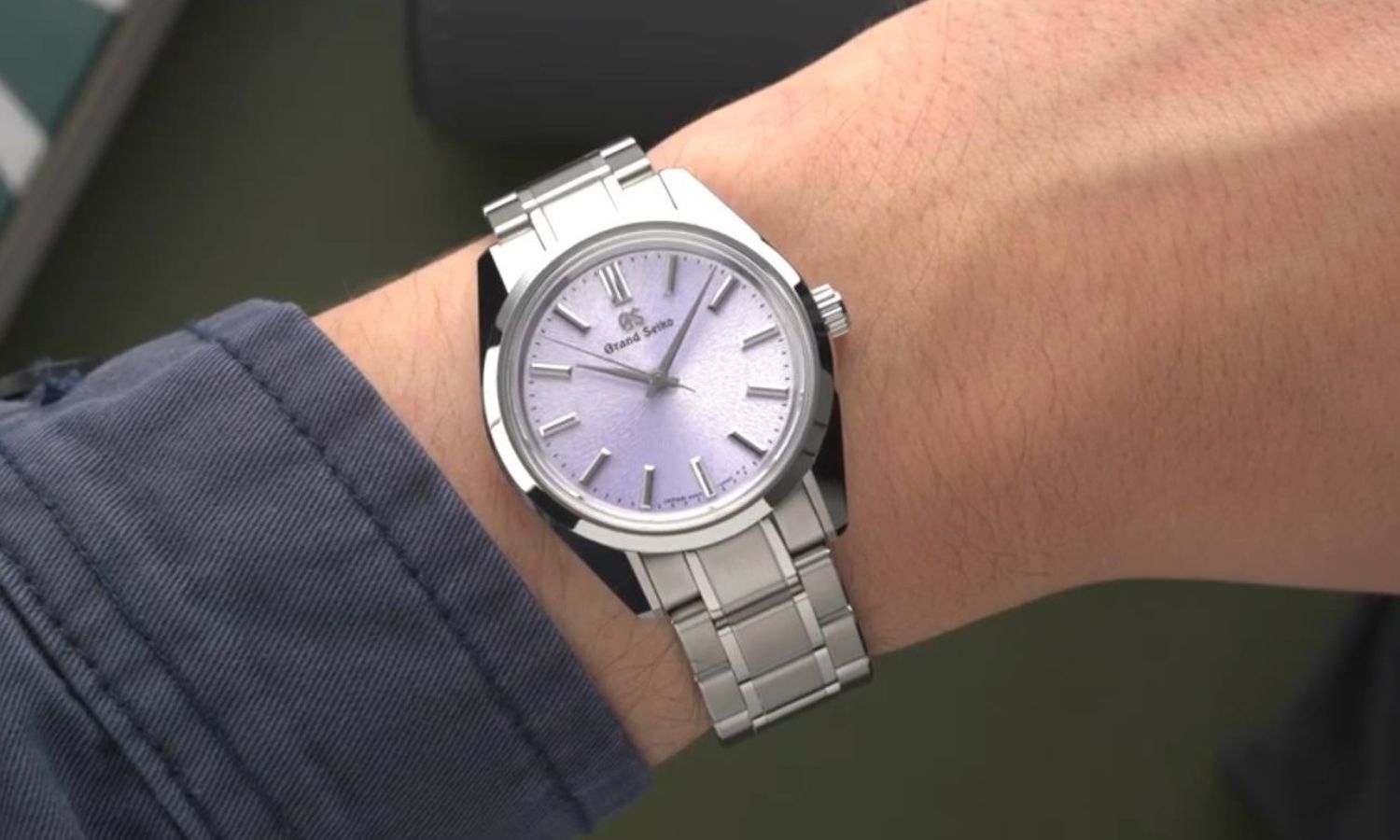 Blick auf die Grand Seiko SBGW323 mit violettem Zifferblatt auf dem Handgelenk eines Mannes.