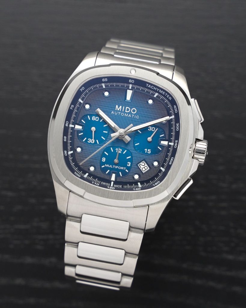Mido Multifort TV Chronograph Referenz: M049.527.11.041.00 mit blauem Zifferblatt am Edelstahlarmband stehend vor schwarzem Hintergrund