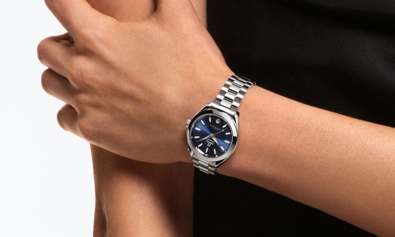 OMEGA Seamaster Aqua Terra 30 mit blauem Zifferblatt am Edelstahlarmband an einem weiblichen Handgelenk getragen vor weißem Hintergrund