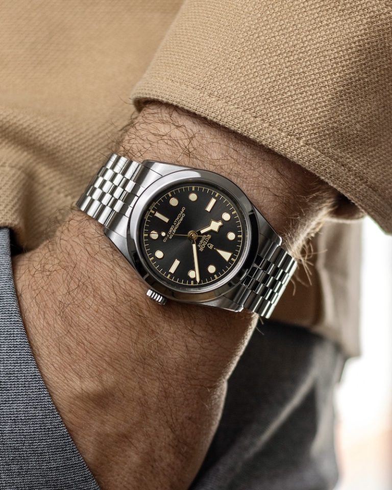 TUDOR Black Bay 39 am Handgelenk eines Mannes mit braunem T-Shirt