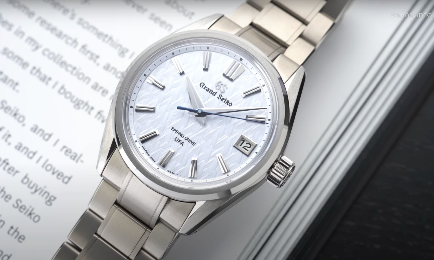 Grand Seiko Evolution 9 SLGB003 Ice Forest mit hellblauem Zifferblatt am Titanarmband auf einem Buch liegend