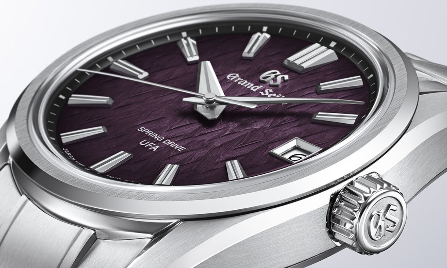 Das Edelstahlgehäuse und das violette Zifferblatt der Grand Seiko SLGB005 „Violet Dawn“ am Edelstahlarmband von oben abgebildet vor weißem Hintergrund