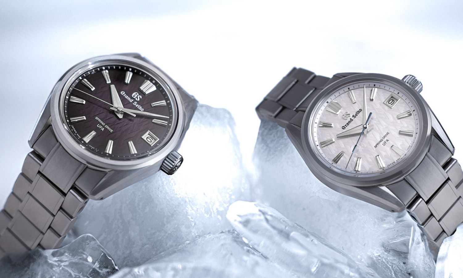 Grand Seiko SLGB005 „Violet Dawn“ mit violettem Zifferblatt am Edelstahlarmband und Grand Seiko SLGB003 „Ice Forest“ mit silbernem Zifferblatt am Titanarmband auf Eis seitlich nebeneinander stehend