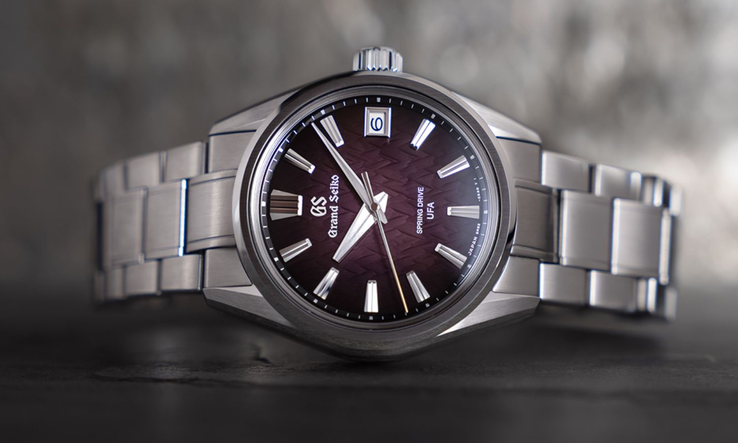 Grand Seiko SLGB005 „Violet Dawn“ mit violettem Zifferblatt am Edelstahlarmband auf der Seite liegend