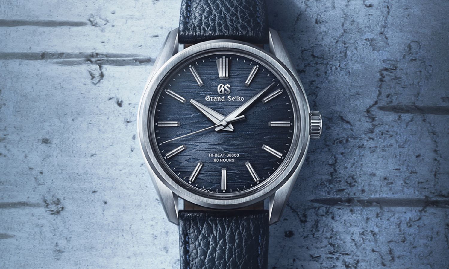 Grand Seiko SLGW007 Moonlit Birch mit blauem Zifferblatt am blauen Rindslederarmband liegend von vorne abgebildet vor hellblauem Hintergrund