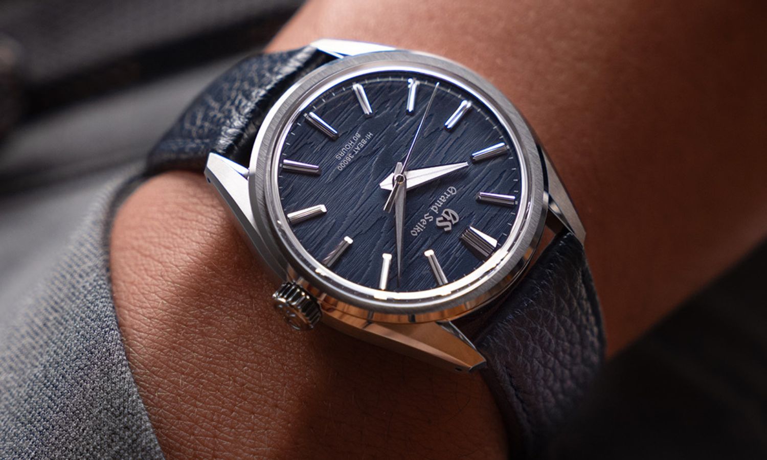 Grand Seiko SLGW007 Moonlit Birch mit blauem Zifferblatt am blauen Rindslederarmband an einem Handgelenk mit der Hand in der Hosentasche getragen