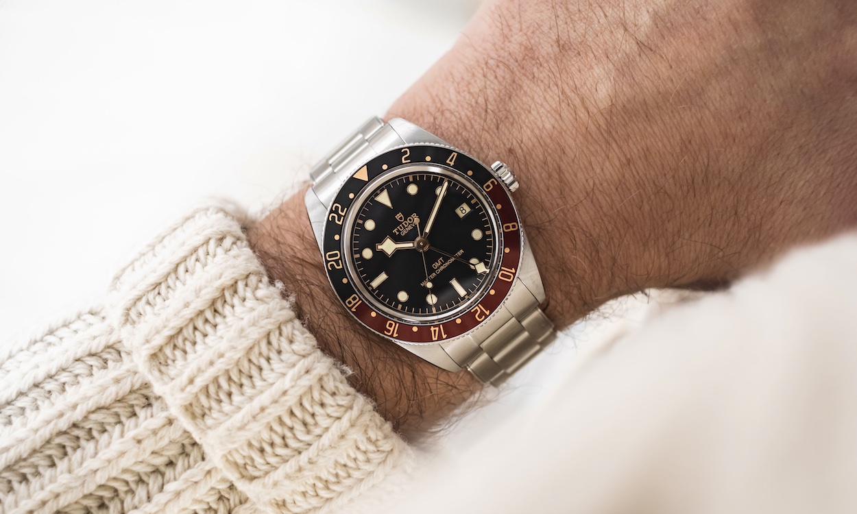 TUDOR Black Bay 58 GMT am Handgelenk eines Mannes mit weißem Pullover
