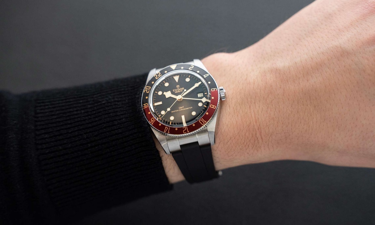 TUDOR Black Bay 58 GMT am Kautschukband am Handgelenk eines Mannes mit schwarzem Pullover