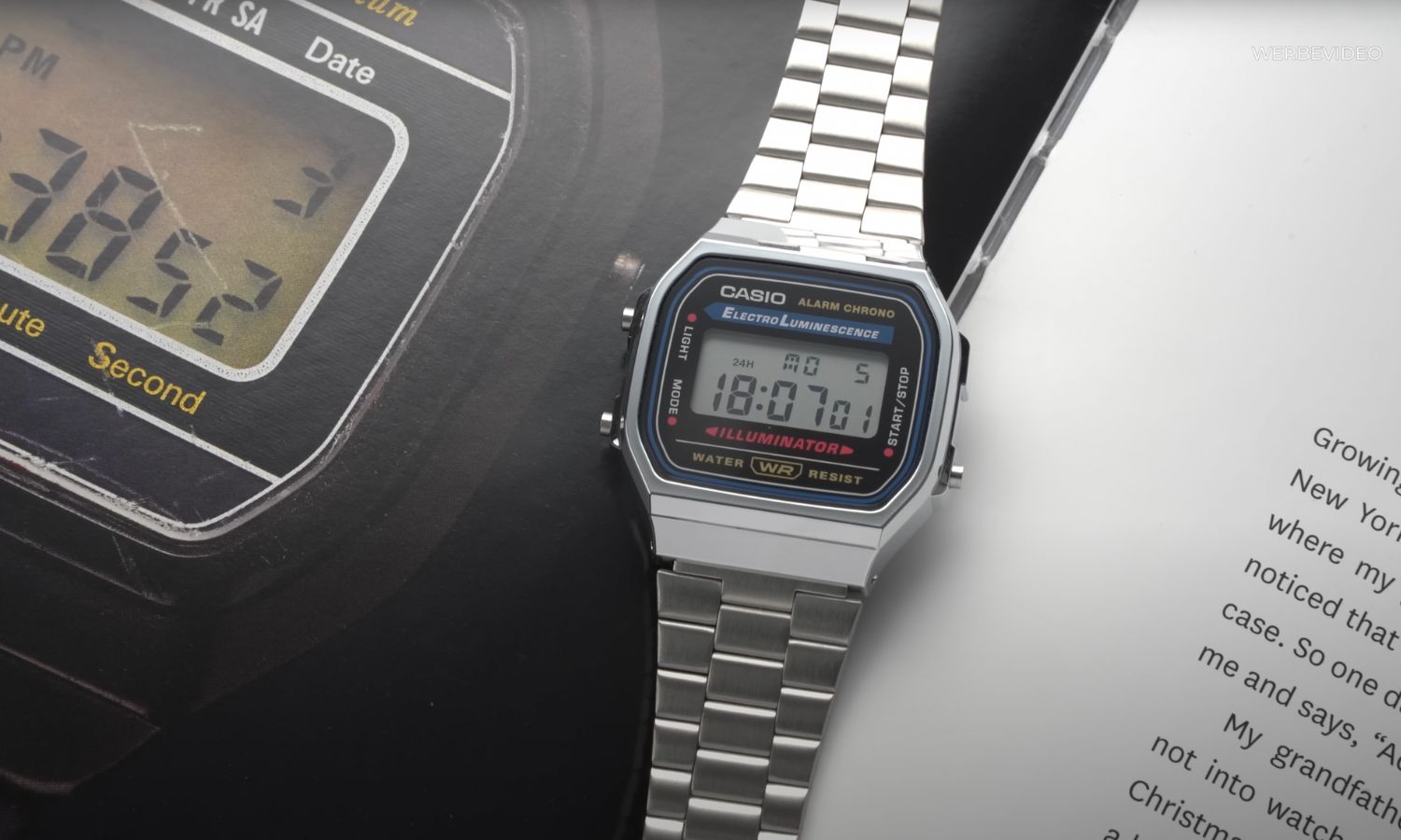 Casio A168 am Edelstahlarmband liegend auf einer Zeitschrift mit Bild einer Casio Uhr