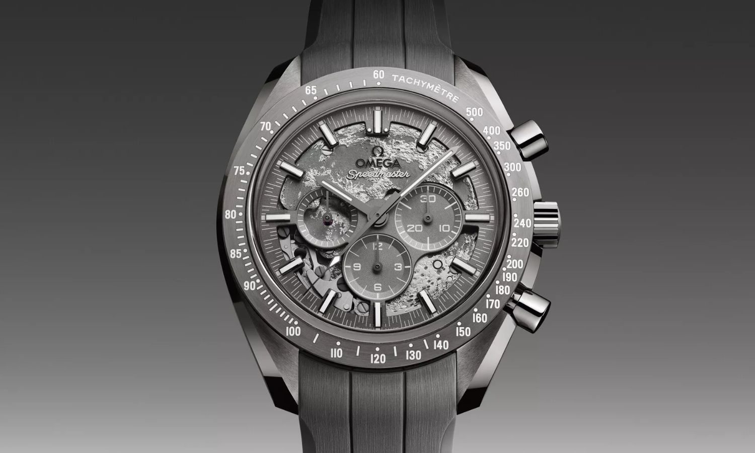 OMEGA Speedmaster Grey Side of the Moon Referenz 310.92.44.50.06.002 mit grauem Zifferblatt stehend von vorne abgebildet vor grauem Hintergrund