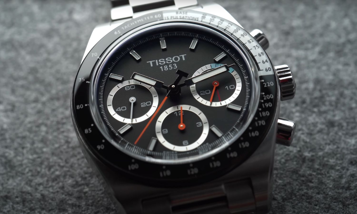 Nahaufnahme des schwarzen Zifferblatts der Tissot PR516 Mechanical Chronograph abgebildet vor grauem Hintergrund
