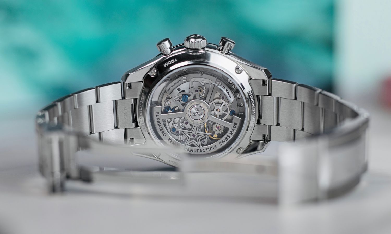 Das El Primero 3600 Kaliber der Zenith Chronomaster Sport am Edelstahlarmband abgebildet vor grünem Hintergrund
