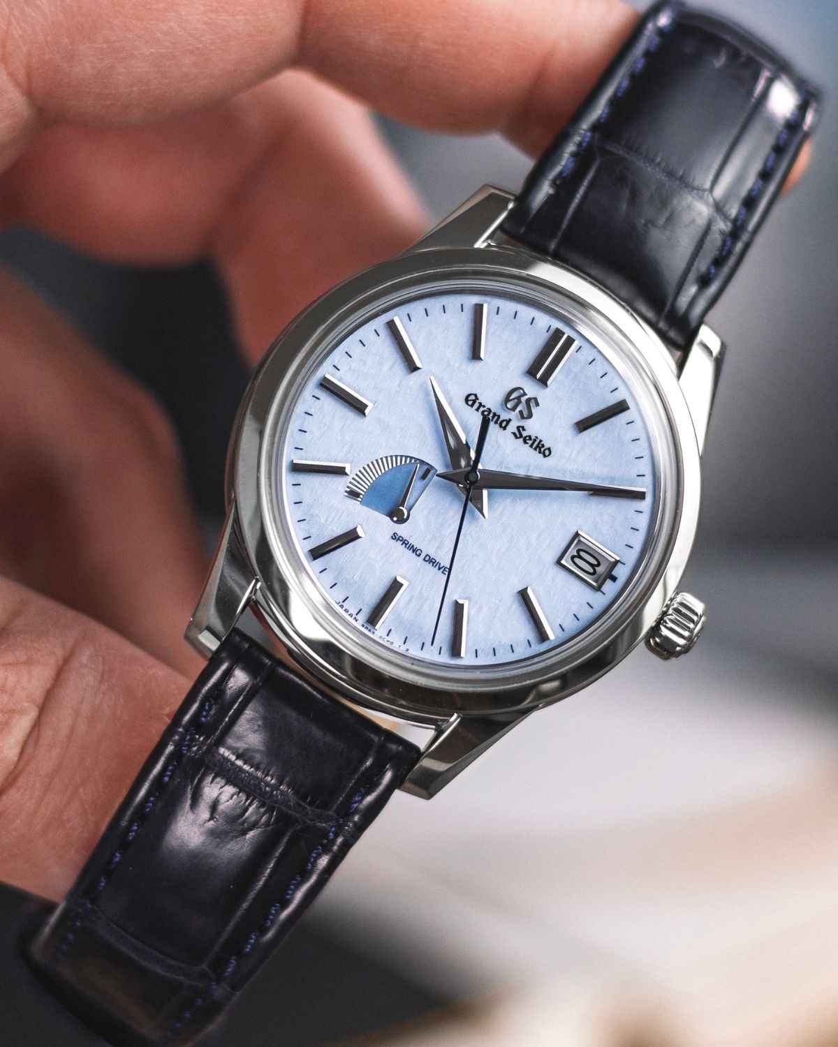 Grand Seiko Snowflake SBGA407 am schwarzen Lederband in der linken Hand gehalten