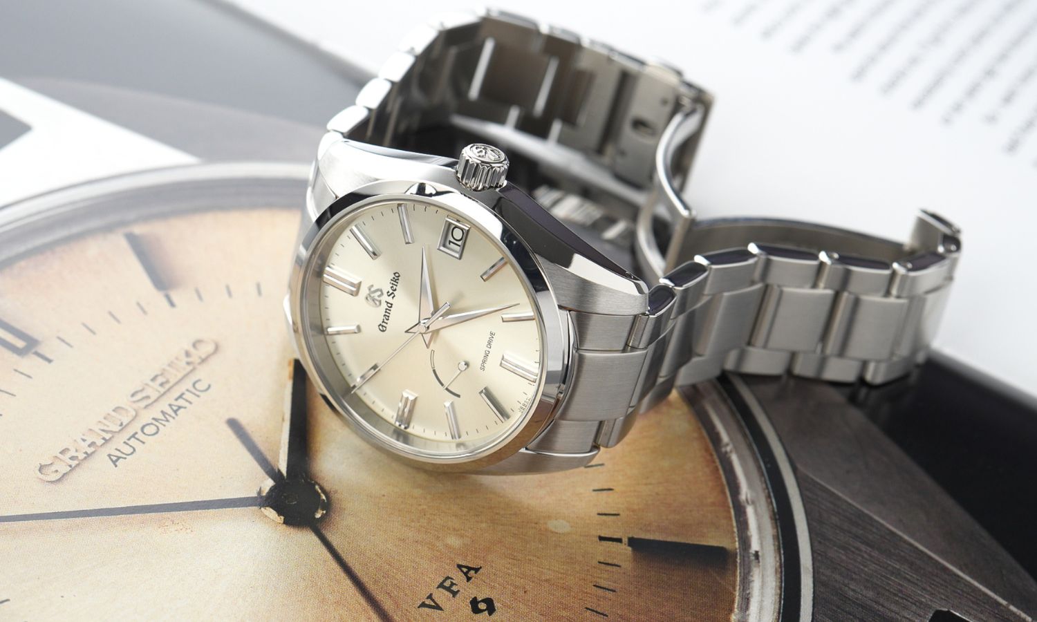 Grand Seiko SBGA437 an Metallarmband fotografiert auf einem Uhrenmagazin liegend