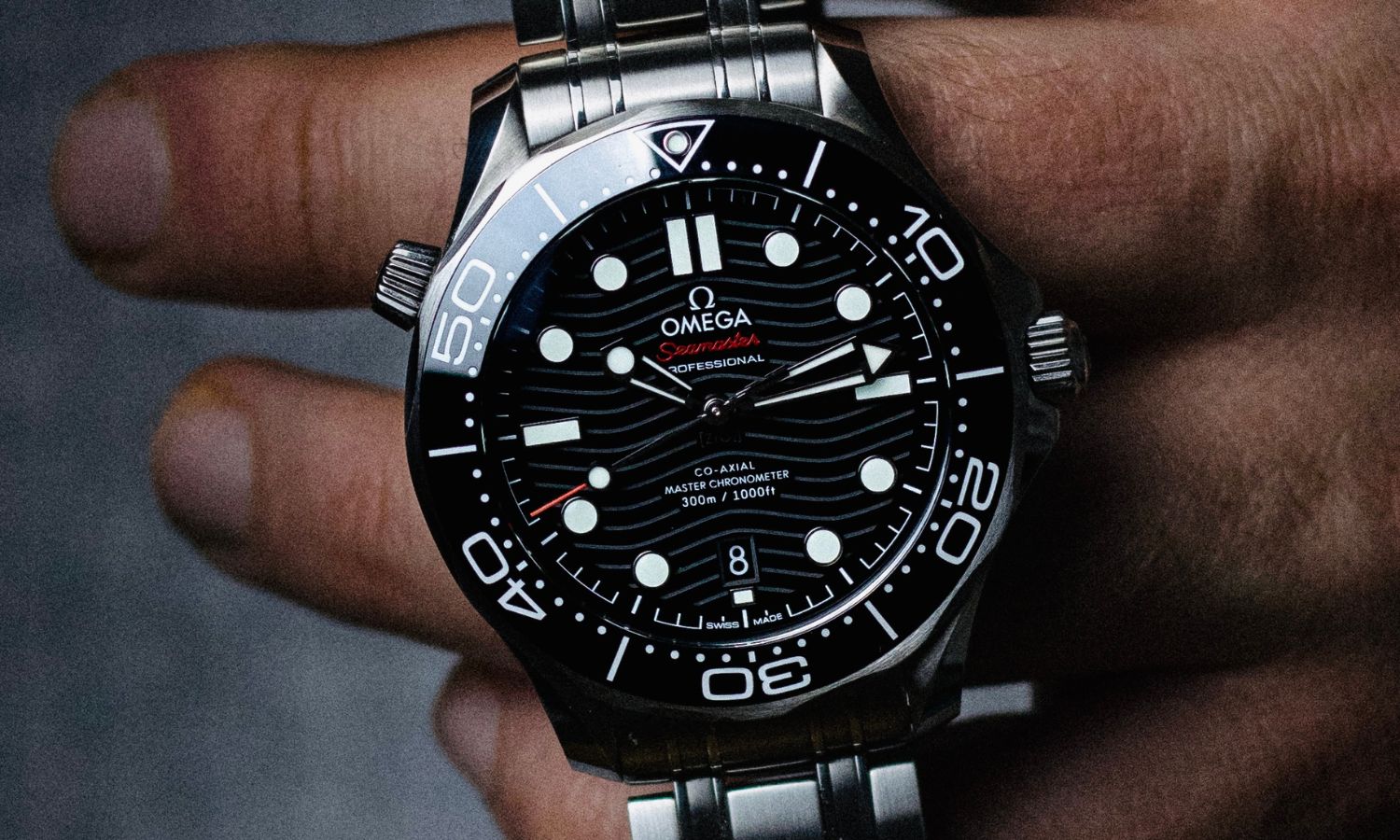 OMEGA Seamaster Diver 300M Referenz 210.30.42.20.01.001 mit schwarzem Zifferblatt am Edelstahlarmband von einer Hand gehalten