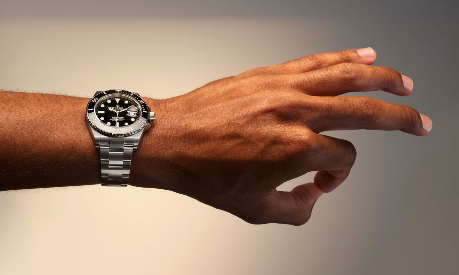 Rolex Submariner Date Referenz 126610LN mit schwarzem Zifferblatt am Edelstahlarmband an einem Handgelenk getragen