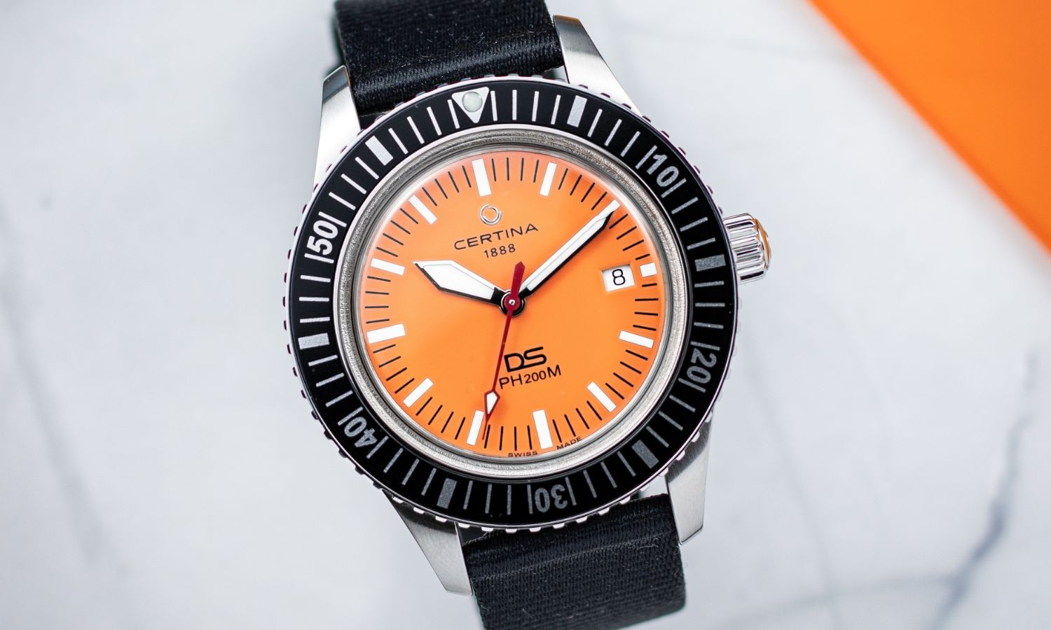Certina DS PH200M Powermatic 80 mit orangenem Zifferblatt von vorne abgebildet vor hellgrauem Hintergrund