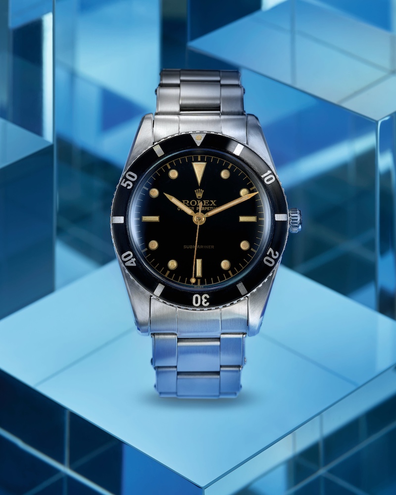 Rolex Submariner der 1950er Jahre vor blauem Hintergrund in Nahaufnahme