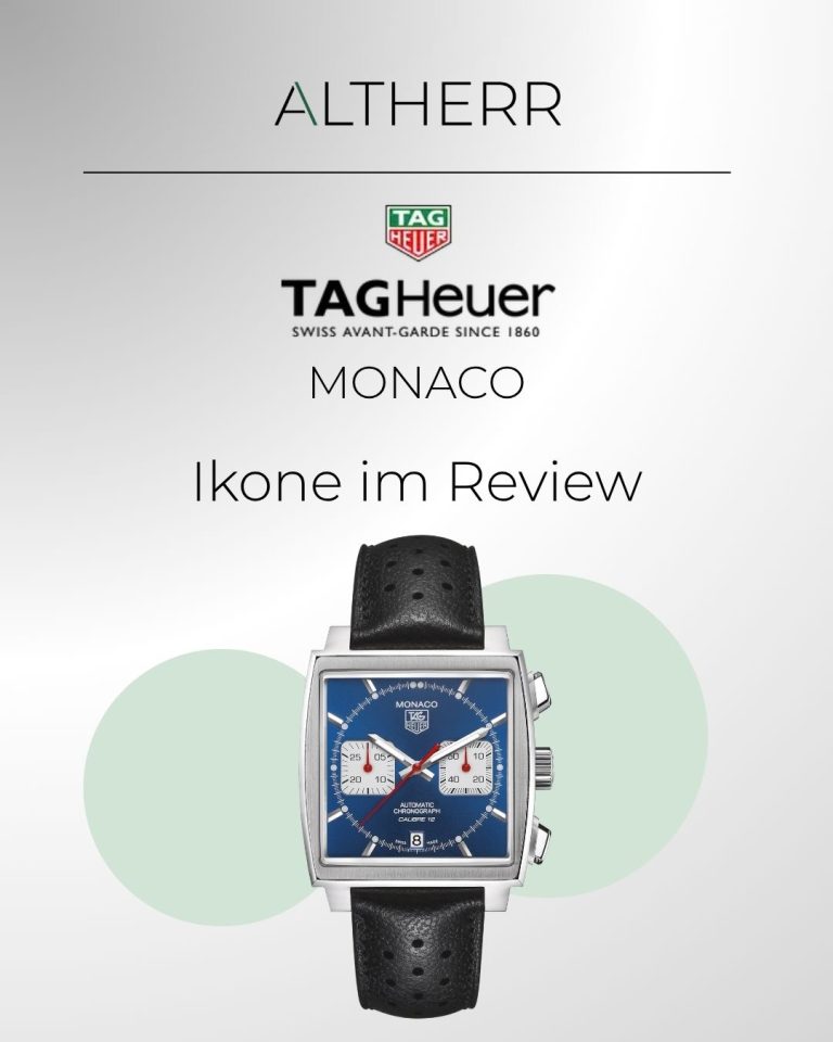 TAG HEUER Monaco Calibre 12 mit blauem Zifferblatt am schwarzen Lederarmband stehend von vorne abgebildet vor grauem Hintergrund mit grünen Kreisen