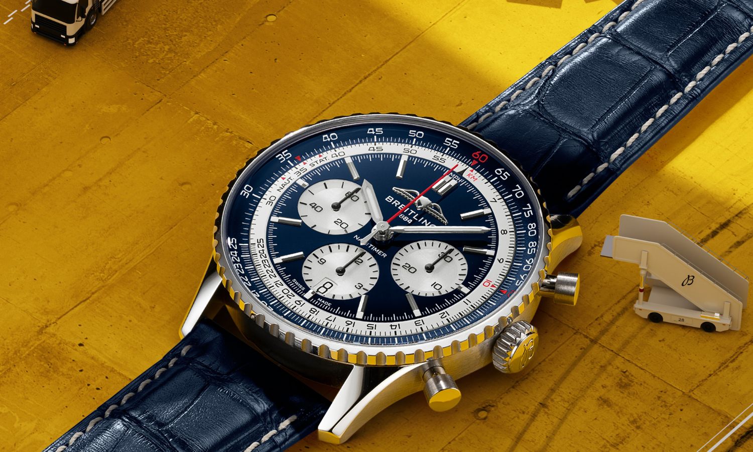 Breitling Navitimer B01 Chronograph 43 Tribute to Concorde mit blauem Zifferblatt am blauen Lederarmband liegend auf gelbem Untergrund