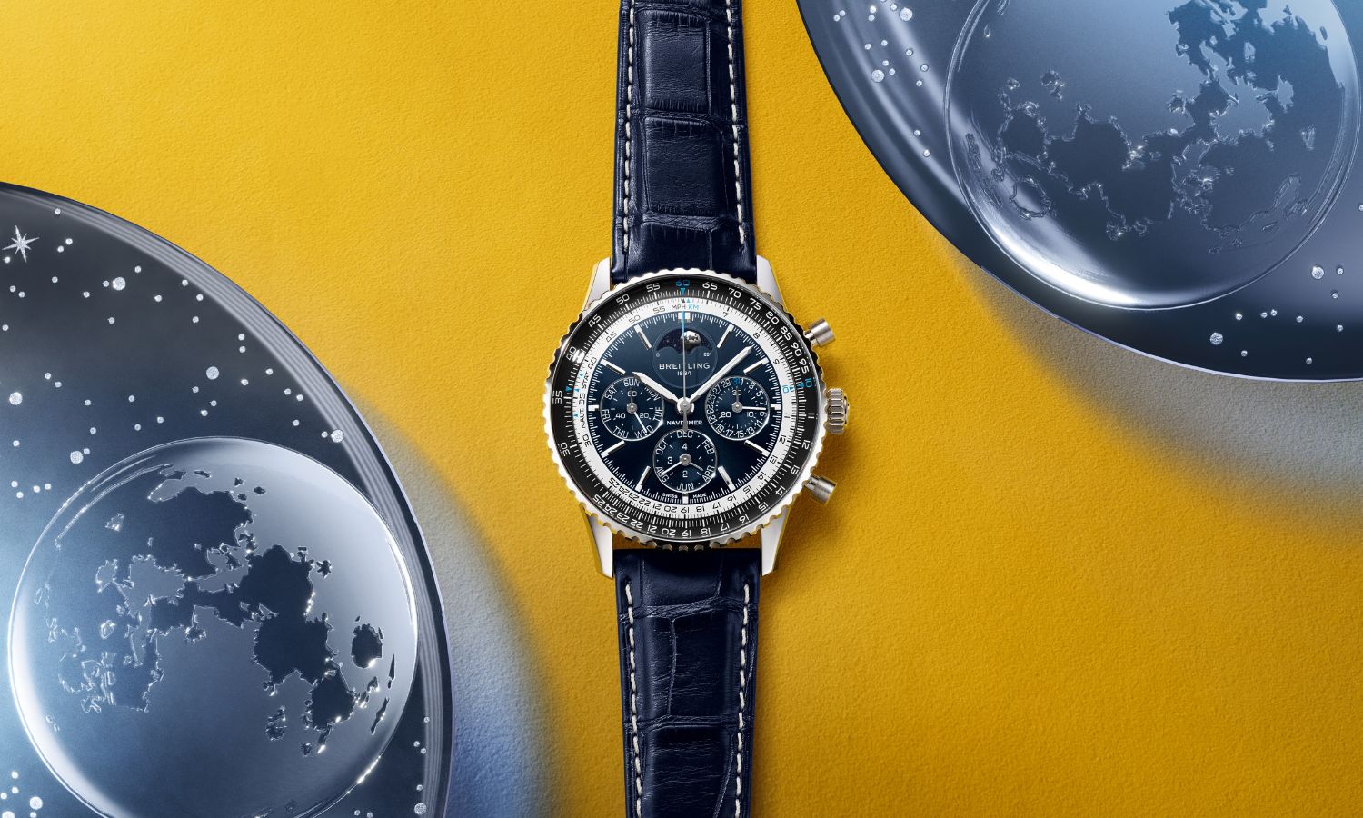 Breitling Navitimer B19 Chronograph 43 Perpetual Calendar mit blauem Zifferblatt am blauen Lederarmband liegend auf gelbem Untergrund