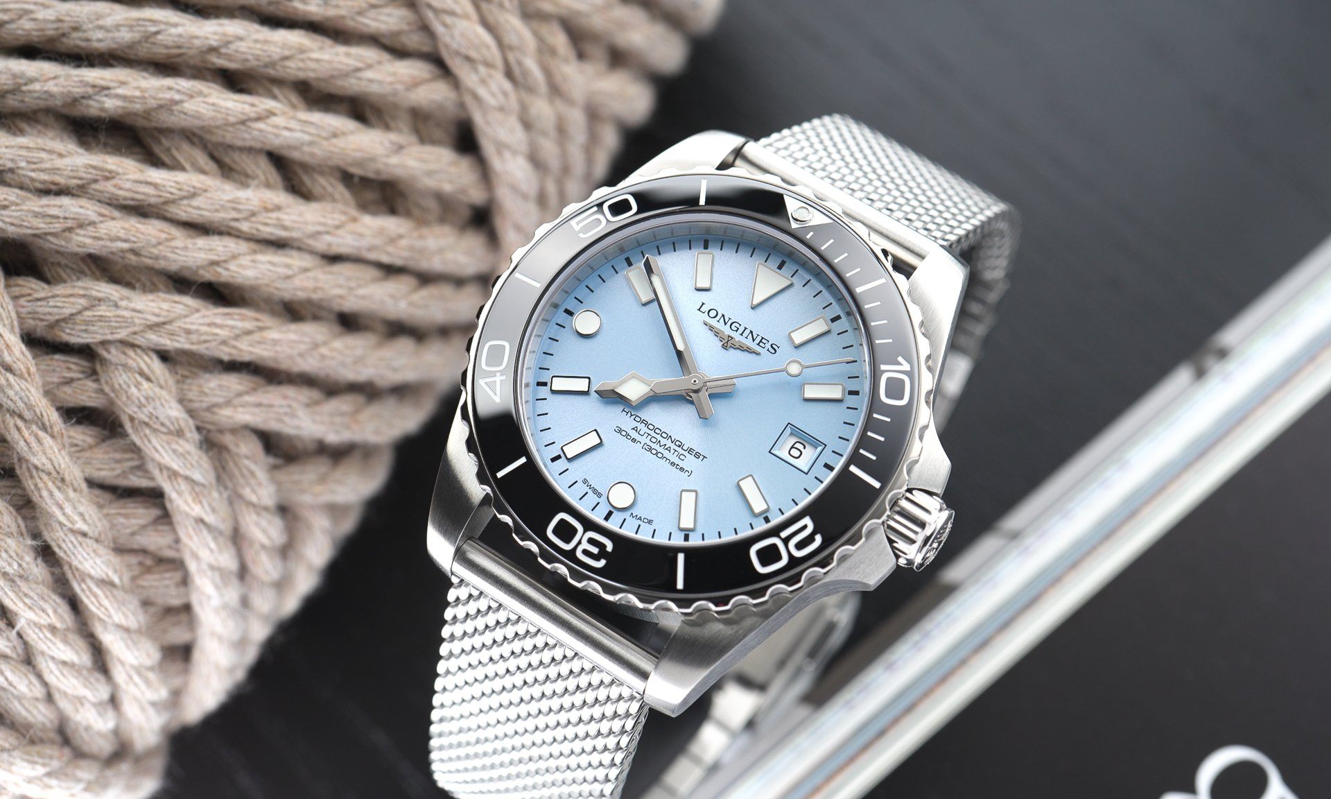 Longines HydroConquest 2026 mit eisblauem Zifferblatt und schwarzer Lünette am Milanaise-Armband stehend von oben abgebildet