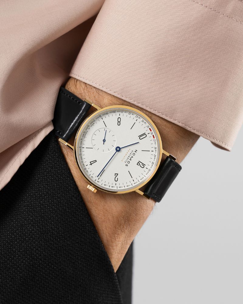 Blick auf die NOMOS neomatik Update in der Goldversion auf dem Handgelenk eines Mannes.