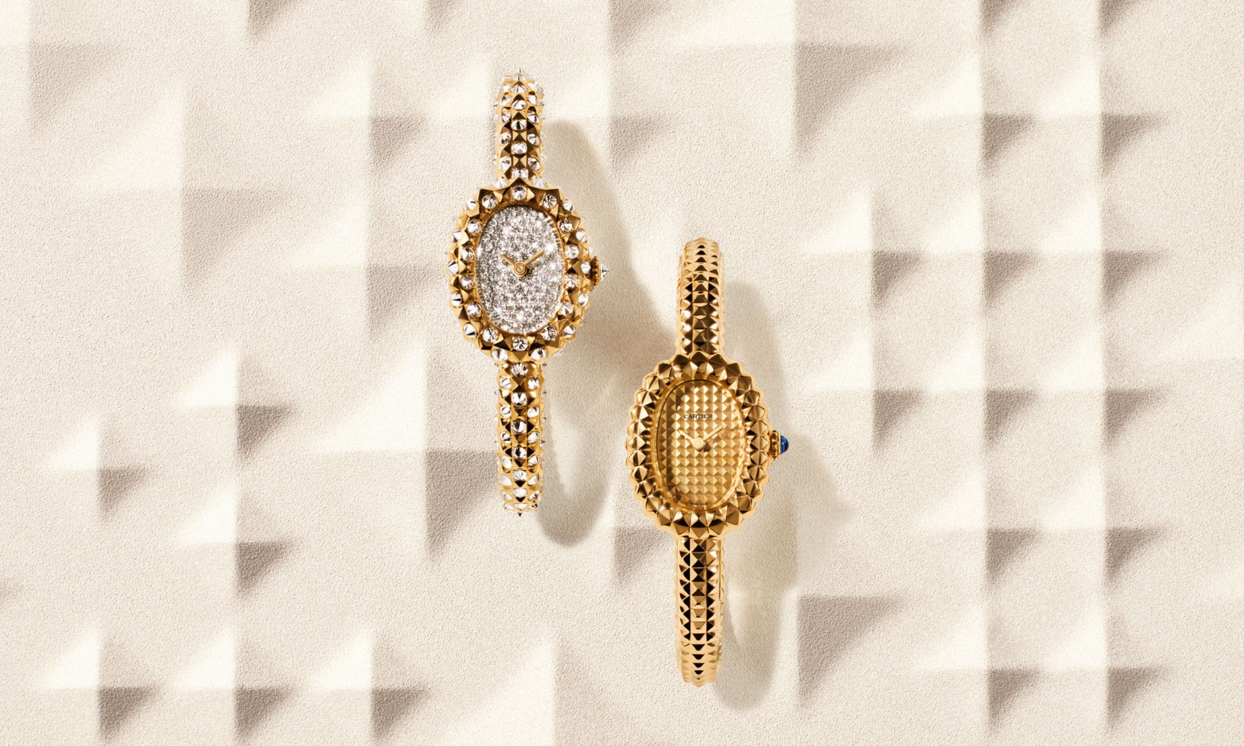 Zwei Cartier Baignoire vor in Edelmetall vor geometrischem Hintergrund