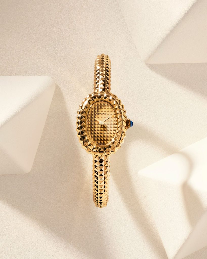 Goldene Cartier Baignoire Clous de Paris von vorne abgebildet vor hellem Hintergrund