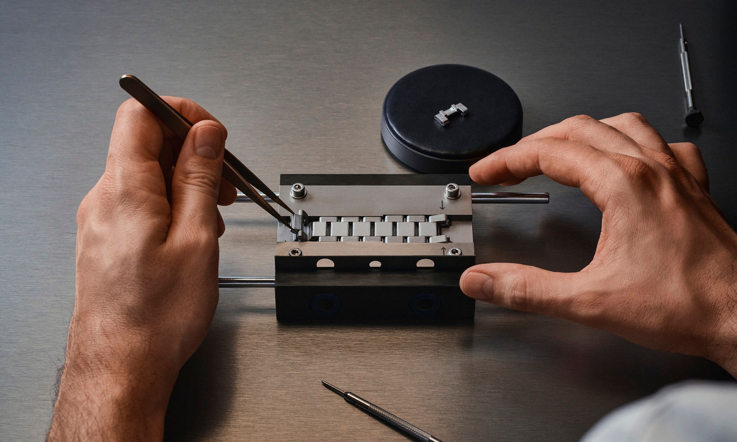 Das Metallarmband einer Cartier Roadster wird in einer Spezialvorrichtung angepasst