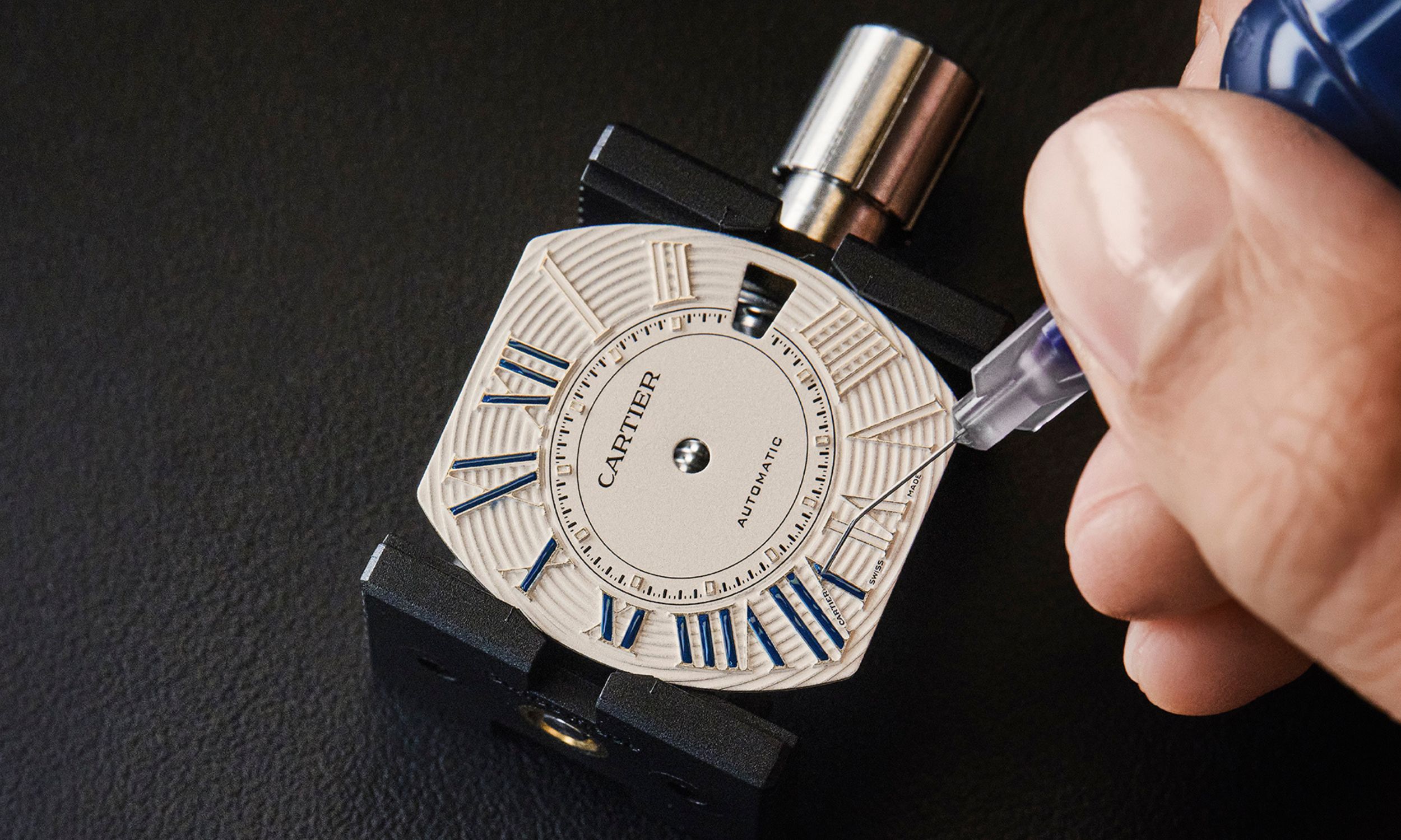 Detailaufnahme des Lackierprozesses des Zifferblatts der Cartier Roadster