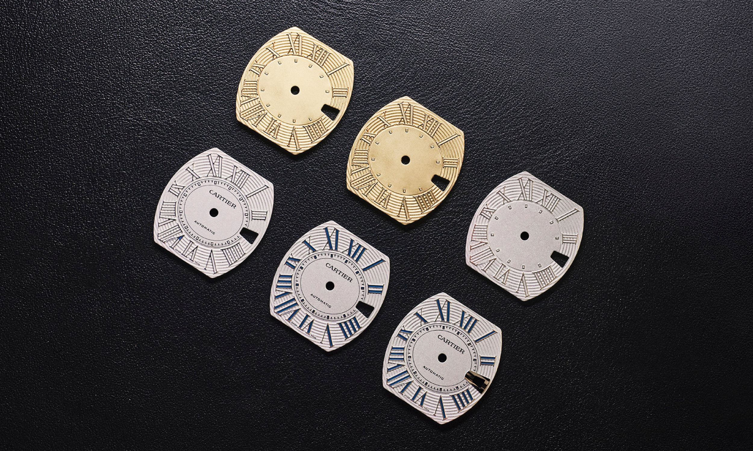 Verschiedene Fertigungsstufen des Zifferblatts der Cartier Roadster vom Rohling bis zum fertigen Blatt