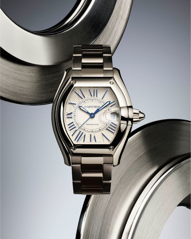 Cartier Roadster mit silbernem Zifferblatt am Edelstahlarmband von vorne abgebildet vor grauem Hintergrund