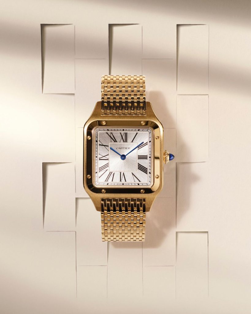 Cartier Santos-Dumont Gelbgold mit silbernem Zifferblatt am Gelbgold-Armband von vorne abgebildet vor hellem Hintergrund