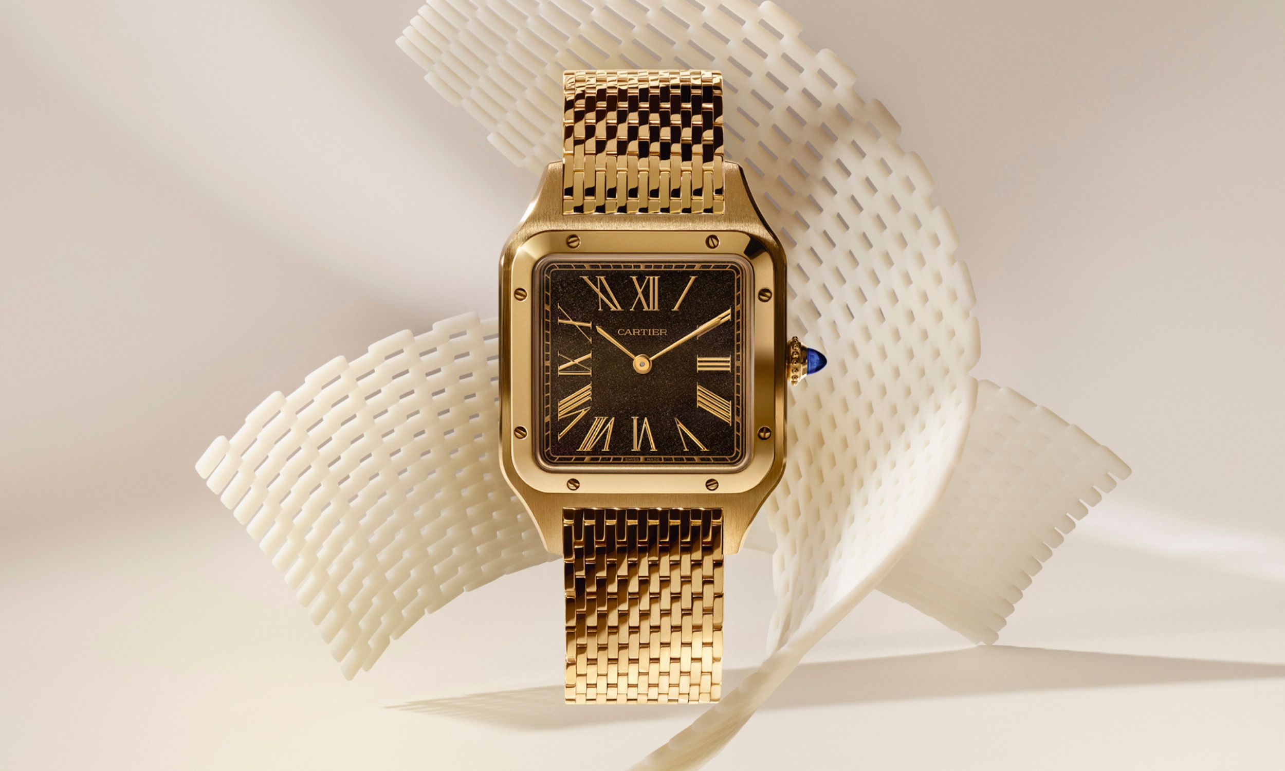 Goldene Cartier Santos-Dumont mit dunkelbraunem Zifferblatt am Edelmetallband vor beigem Schleifenhintergrund