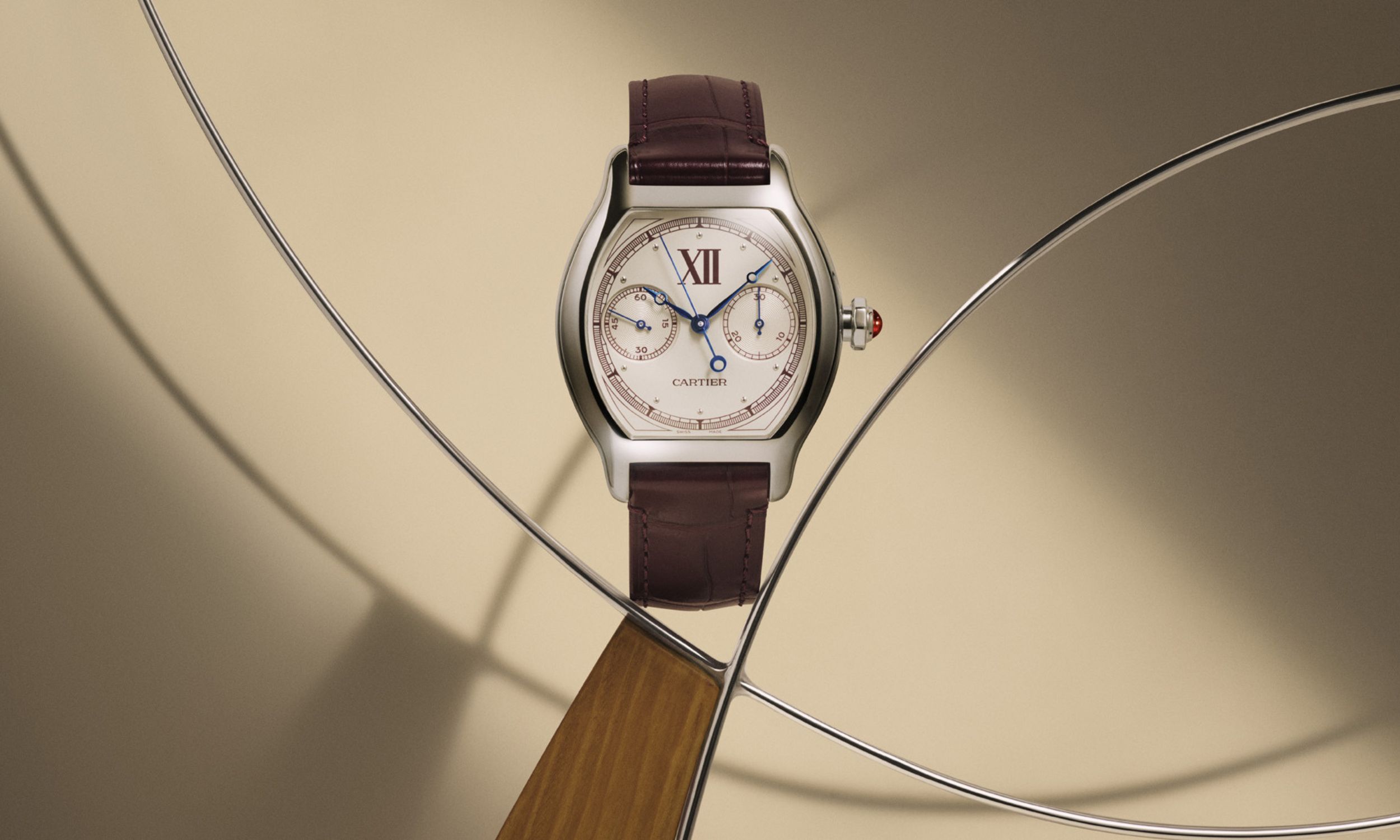 Cartier Tortue Monopusher-Chrono in der Frontalansicht vor beigem Hintergrund mit Draht