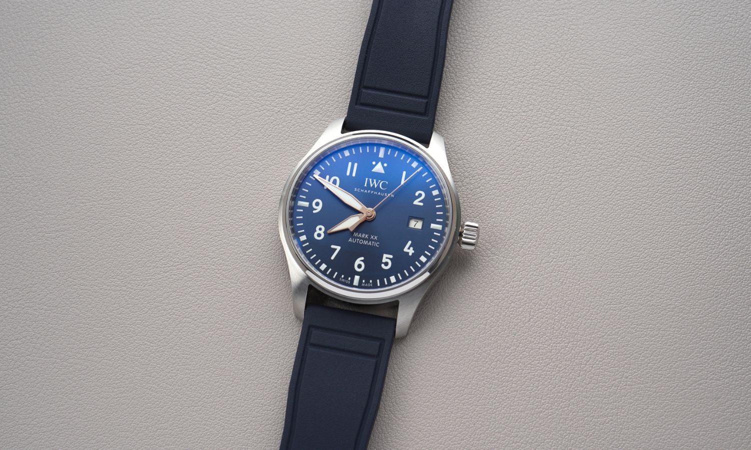 IWC Mark XX Le Petit Prince IW328221 mit dunkelblauem Zifferblatt am dunkelblauen Gummiband liegend auf grauem Untergrund