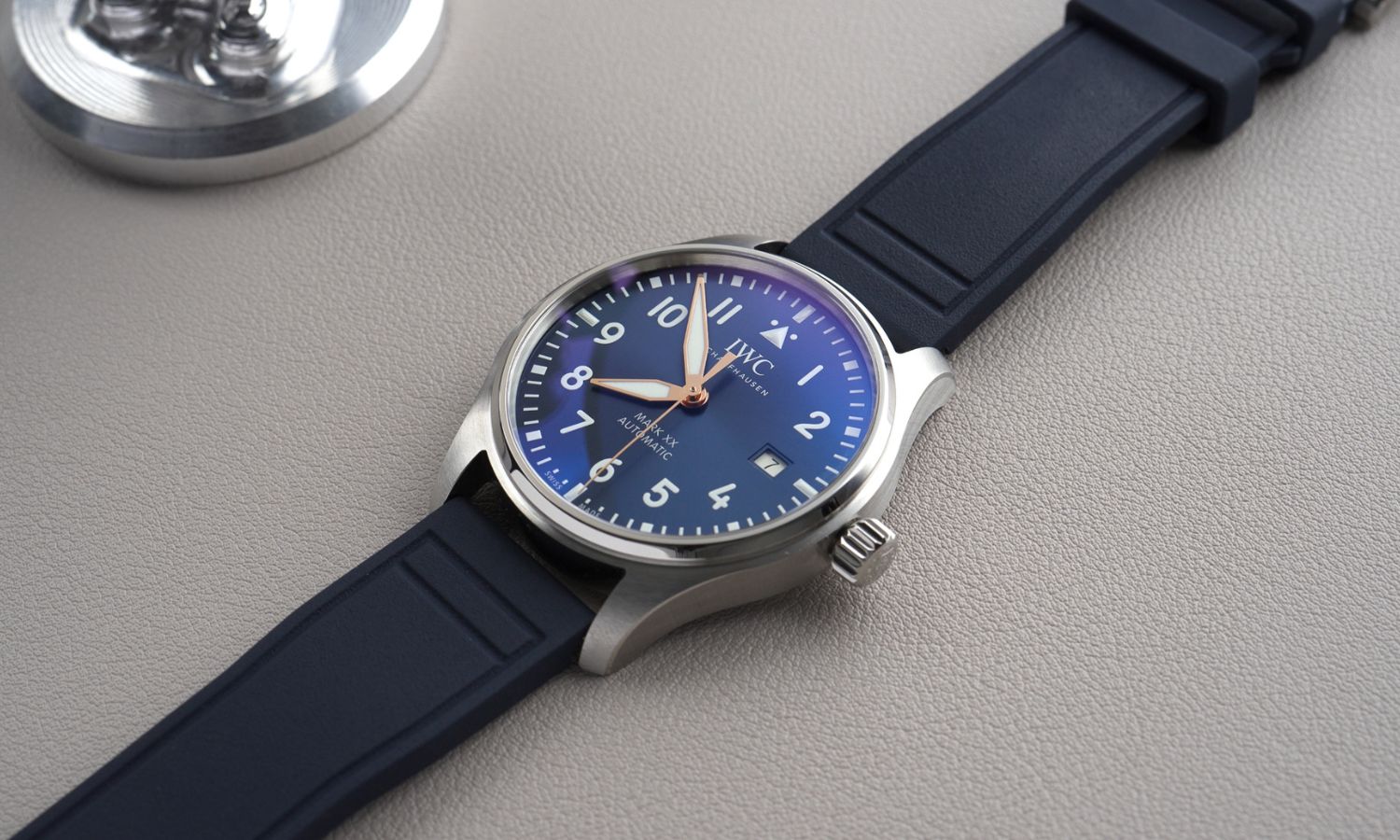 IWC Mark XX Le Petit Prince IW328221 mit dunkelblauem Zifferblatt am dunkelblauen Gummiband seitlich liegend auf grauem Untergrund