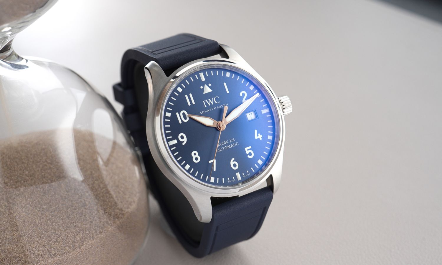 IWC Mark XX Le Petit Prince IW328221 mit dunkelblauem Zifferblatt am dunkelblauen Gummiband stehend vor grauem Hintergrund