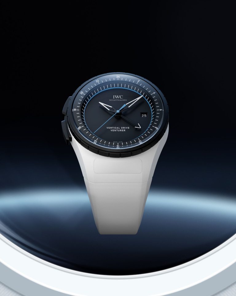 IWC Pilot’s Venturer Vertical Drive mit dunkelblauem Zifferblatt am weißen Gummiarmband abgebildet vor dunkelblauem Hintergrund