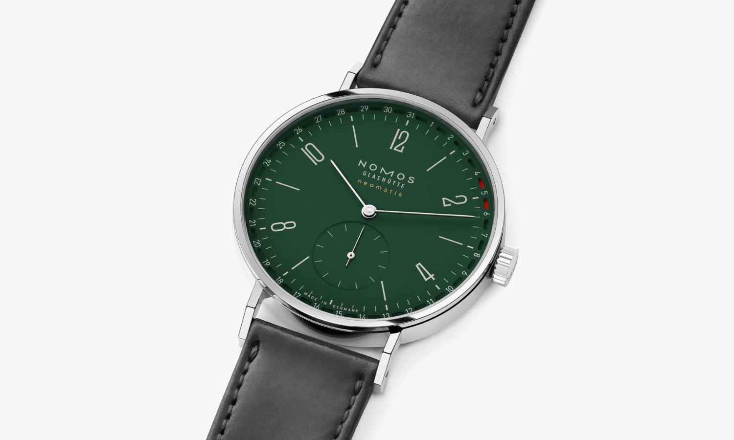 NOMOS Glashütte Tangente neomatik 38 Update mit waldgrünem Zifferblatt am schwarzen Lederarmband liegend auf weißem Untergrund