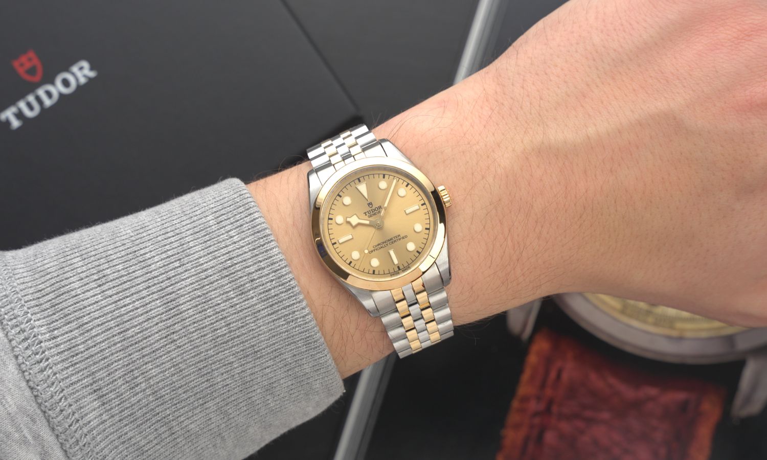 TUDOR Black Bay 36 S&G Referenz M79643-0005 mit champagnerfarbenem Zifferblatt am Edelstahlarmband an einem Handgelenk mit hellgrauem Ärmel getragen