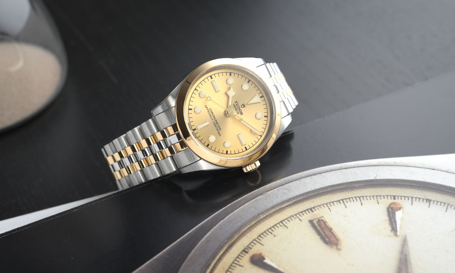 TUDOR Black Bay 36 S&G Referenz M79643-0005 mit champagnerfarbenem Zifferblatt am Edelstahlarmband seitlich liegend auf schwarzem Untergrund